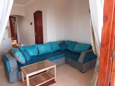 a blue couch in a living room with a table at Luxor Plaza House in Luxor
