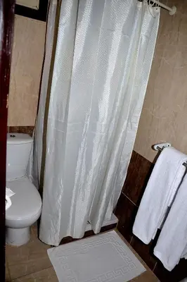 a bathroom with a toilet and a shower curtain at Sand Beach Resort in Hurghada