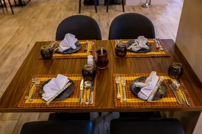 a table with two chairs and a table with plates and napkins at Bellagio Beach Resort & Spa in Hurghada