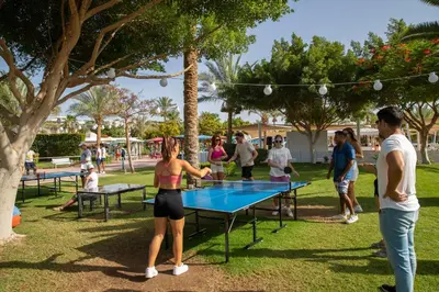 a group of people playing ping pong in a park at Desert Rose in Hurghada