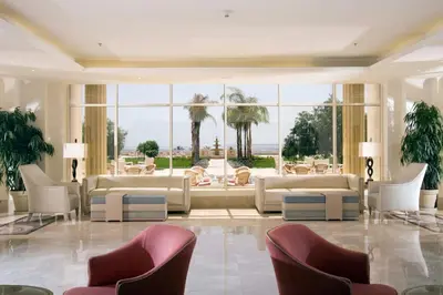 a lobby with white furniture and large windows at Old Palace Resort Sahl Hasheesh in Hurghada