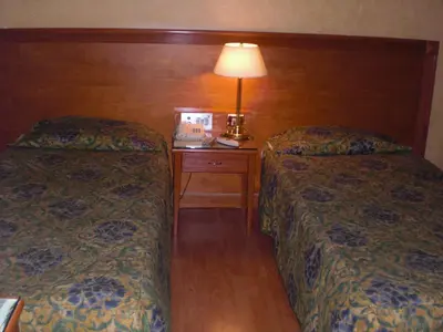 a hotel room with two beds and a table with a lamp at Philippe Luxor Hotel in Luxor