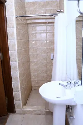 a bathroom with a sink and a toilet and a shower at Lilly Rooms and Studio in Hurghada
