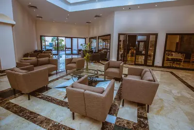 a lobby with chairs and tables and windows at Sky View Suites Hotel in Hurghada