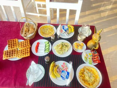 a table with plates of food on a red table at El Mesala Hotel in Luxor
