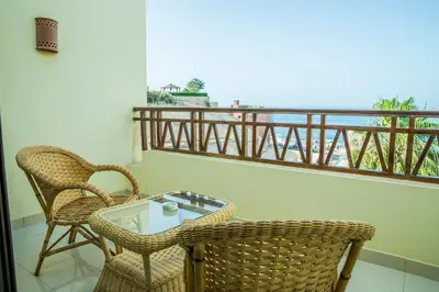 a balcony with two chairs and a glass table at The View Apartment in Hurghada