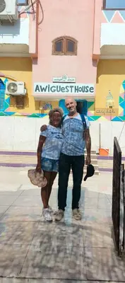 a man and a woman standing in front of a building at Awi Guest House in Aswan