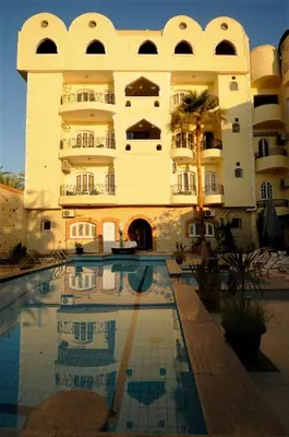 a hotel with a swimming pool in front of a building at Nile Valley Hotel in Luxor