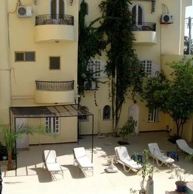 a courtyard with lounge chairs in front of a building at Nile Valley Hotel in Luxor