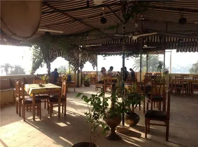 a restaurant with tables and chairs and people sitting at them at Nile Valley Hotel in Luxor
