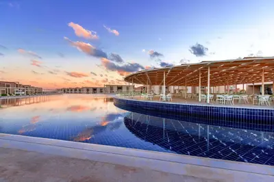 a swimming pool with tables and chairs on a building at Pickalbatros Sea World Resort - Marsa Alam- 