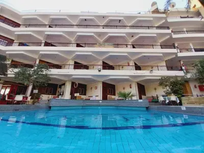 a large building with a large swimming pool at Rezeiky Hotel & Camp 您在盧克索的第二個家 in Luxor