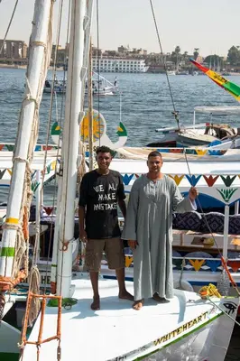 two men standing on top of a sail boat at Villa Sunrise in Luxor