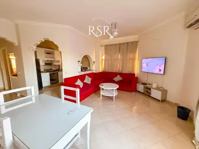 a living room with a red couch and a table at Green Garden Resort in Hurghada