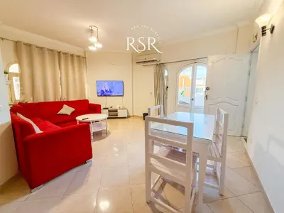 a living room with a red couch and a table at Green Garden Resort in Hurghada