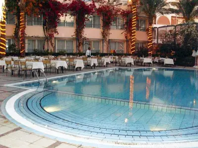 a large swimming pool in a hotel with tables and chairs at Sea Garden Hotel in Hurghada