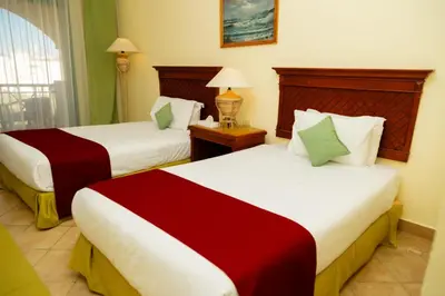 a hotel room with two beds and a window at Sun & Sea Hotel and Aqua Park - Hurghada in Hurghada