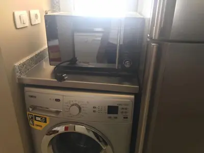 a microwave sitting on top of a washing machine at Joubal Apartment in Hurghada