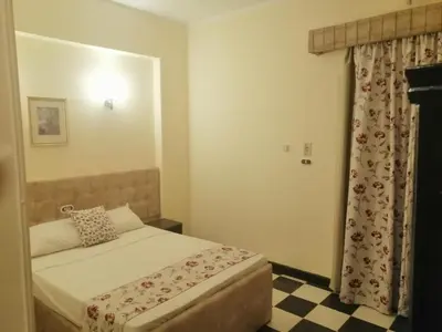 a bedroom with a bed and a checkerboard floor at Royal City Hotel in Hurghada