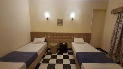 two beds in a room with a checkered floor at Royal City Hotel in Hurghada