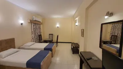 a hotel room with two beds and a mirror at Royal City Hotel in Hurghada