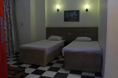 a bedroom with two beds and a checkered floor at Royal City Hotel in Hurghada