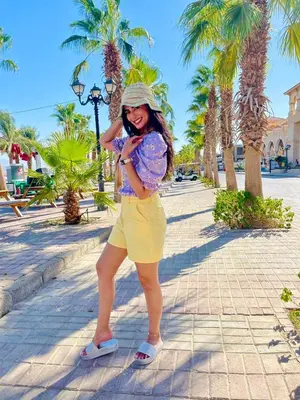 a woman in yellow shorts and a hat standing on a street at Luxury Villa with pool in Hurghada in Hurghada