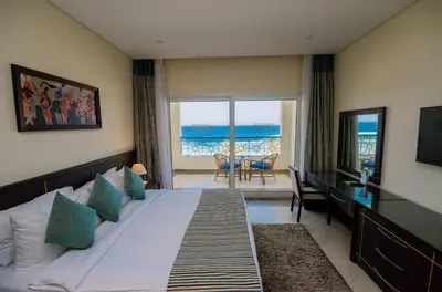a bedroom with a bed and a view of the ocean at Concorde Moreen Beach Resort in Abu Dabab