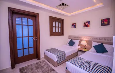 a bedroom with two beds and a door at Concorde Moreen Beach Resort in Abu Dabab