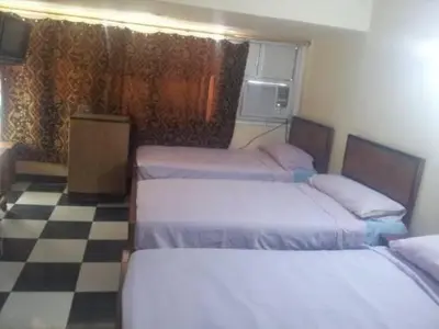 a bedroom with two beds and a checkered floor at Nubian oasis hotel in Aswan