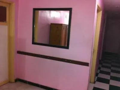a pink wall with a mirror in a room at Nubian oasis hotel in Aswan