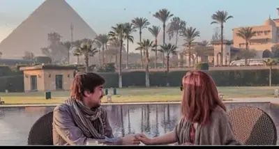 a man and a woman sitting in front of the pyramids at Nubian oasis hotel in Aswan