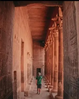 a young boy standing in an alley with columns at Nubian oasis hotel in Aswan