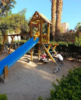 two children playing on a playground with a slide at Cordoba Suites in Hurghada