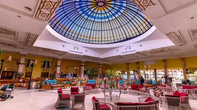 a large lobby with chairs and a glass ceiling at Ali Baba Palace Resort in Hurghada