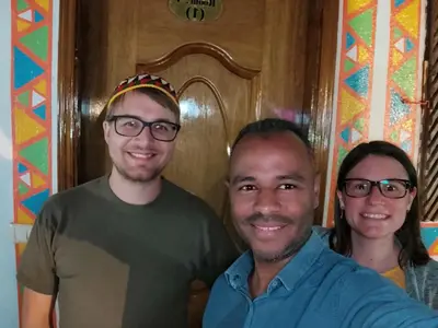 two men and a woman standing in front of a door at Maghrabi's Guest house in Aswan