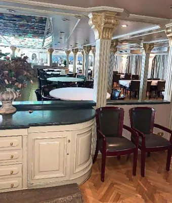 a bar in a restaurant with two chairs and a table at King Tut I Nile Cruise - Every Monday 4 Nights from Luxor - Every Friday 7 Nights from Aswan in Luxor