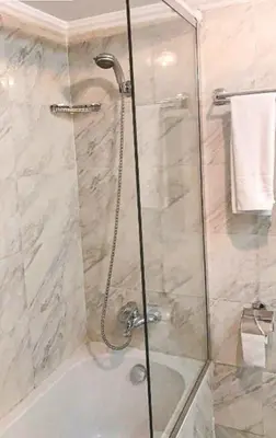 a shower with a glass door in a bathroom at King Tut I Nile Cruise - Every Monday 4 Nights from Luxor - Every Friday 7 Nights from Aswan in Luxor