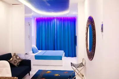 a bedroom with a bed and a blue curtain at SeaView Turtles in Hurghada