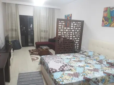 a bedroom with a bed and a chair in it at Aldau Heights in Hurghada