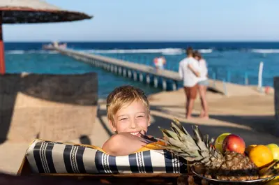 a young boy laying in an inflatable at Three Corners Happy Life Beach Resort in Abu Dabab