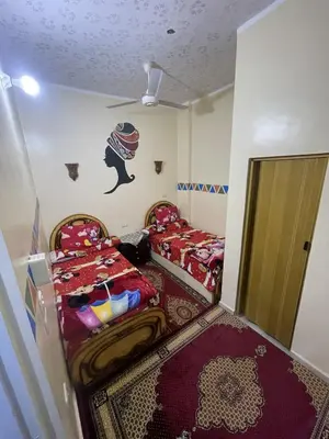 a small room with two beds and a door at Shater Nubian House in Aswan