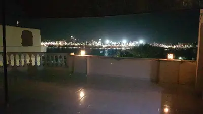a view of a city at night from a balcony at Nile Sunrise Flats And Rooms in Luxor