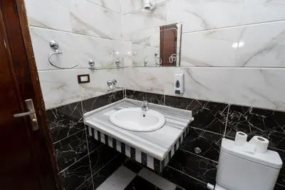 a bathroom with a sink and a toilet at Nile Sunrise Flats And Rooms in Luxor