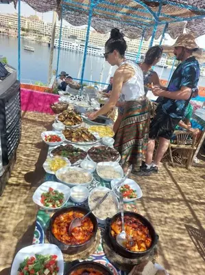a table with many plates of food on it at Bob Marley Guest House in Aswan