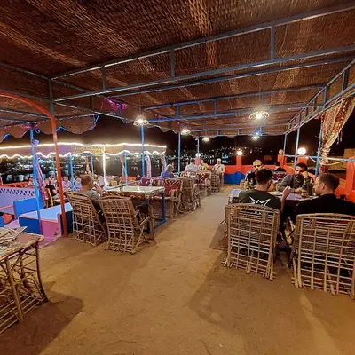a group of people sitting in chairs at a restaurant at Bob Marley Guest House in Aswan