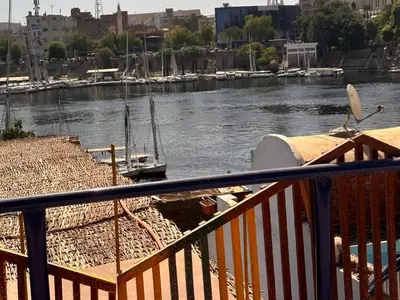 a boat sitting on the water next to a dock at Nuba Dool in Aswan