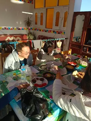 a group of people sitting around a table eating food at Nuba Dool in Aswan