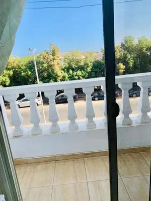 a balcony with a white railing and cars on a street at Solider Art in Hurghada