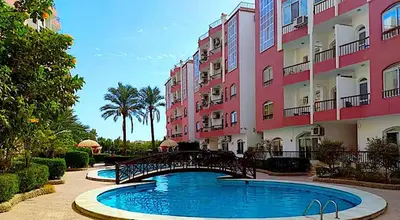 a bridge over a swimming pool in front of a building at Desert Pearl Art in Hurghada